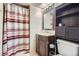 Bathroom featuring a striped shower curtain, dark wood vanity, and convenient storage cabinet at 8438 Prairie Clover Way, Parker, CO 80134