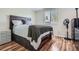 Serene bedroom featuring wood-look floors, a modern bed frame, and a bright window for natural light and comfort at 8438 Prairie Clover Way, Parker, CO 80134