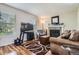 Inviting living room featuring a cozy fireplace, wood floors, and bright natural light from the windows at 8438 Prairie Clover Way, Parker, CO 80134