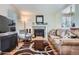 Spacious living room featuring a stone fireplace, hardwood floors, and comfortable seating for relaxation and entertaining at 8438 Prairie Clover Way, Parker, CO 80134