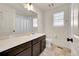 Full bathroom with dark brown vanity, shower/tub combo, and a window at 10096 Zeno St, Commerce City, CO 80022