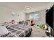 Cozy bedroom with a plaid comforter, large window, and a TV at 10096 Zeno St, Commerce City, CO 80022