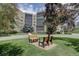 Well-maintained building exterior with manicured lawn, seating and mature trees at 13631 E Marina Dr # 109, Aurora, CO 80014