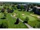 Expansive view of the golf course near condo buildings, surrounded by lush greenery and mature trees at 13631 E Marina Dr # 109, Aurora, CO 80014