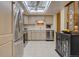 Bright kitchen featuring stainless steel appliances, white cabinetry, and ample counter space, enhanced by a skylight at 13631 E Marina Dr # 109, Aurora, CO 80014