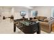 This basement features a sofa, a foosball table, and a window with a view of the backyard at 10968 Lewiston St, Commerce City, CO 80022