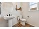 Bathroom with floating vanity and toilet with natural light from the window at 10968 Lewiston St, Commerce City, CO 80022