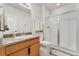 Bright bathroom features a tile shower with glass door and vanity with cabinet at 10968 Lewiston St, Commerce City, CO 80022