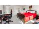 This bedroom offers a red bed and black chair in front of a window with neighborhood views at 10968 Lewiston St, Commerce City, CO 80022