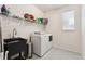 This laundry room is equipped with a sink, shelving, a window, and a washer and dryer at 10968 Lewiston St, Commerce City, CO 80022