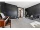 A flex room with black walls and carpet viewed through a set of French doors at 10968 Lewiston St, Commerce City, CO 80022