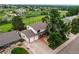Aerial view of a lovely home with a spacious yard, mature trees, and a two-car garage at 10137 W Berry Dr, Littleton, CO 80127