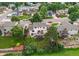 Aerial view shows a well-kept home with a spacious backyard, deck, mature trees, and fenced yard at 10137 W Berry Dr, Littleton, CO 80127