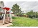 Large grassy backyard with a trampoline, storage shed, and deck access, great for outdoor activities at 10137 W Berry Dr, Littleton, CO 80127