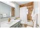 Bathroom features stylish vanity with framed mirror, tiled shower with tub and linen storage at 10137 W Berry Dr, Littleton, CO 80127