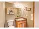 Cozy bathroom with wood vanity and a decorative mirror at 10137 W Berry Dr, Littleton, CO 80127
