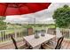 Outdoor deck with table, chairs, decorative lanterns, and neighborhood views beyond at 10137 W Berry Dr, Littleton, CO 80127
