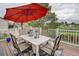 Relaxing deck with outdoor dining set, red umbrella, and scenic view of nature at 10137 W Berry Dr, Littleton, CO 80127