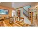 Dining area featuring a rustic table, stairs, and artwork, bathed in natural light from the window at 10137 W Berry Dr, Littleton, CO 80127