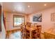 Bright dining room features a wooden table with seating for six, and a window with natural light at 10137 W Berry Dr, Littleton, CO 80127