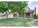 Beautiful home with a large tree in the front yard, a well-maintained lawn, and a cozy front porch at 10137 W Berry Dr, Littleton, CO 80127