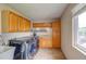 Well-equipped laundry room with large window, washer, dryer, and built-in storage cabinets at 10137 W Berry Dr, Littleton, CO 80127