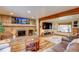 Cozy living room with a stone fireplace, wood beam, large TV, and plush seating arrangement at 10137 W Berry Dr, Littleton, CO 80127