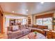 Open-concept living room with a comfortable sectional, a fireplace, and access to kitchen and dining area at 10137 W Berry Dr, Littleton, CO 80127