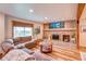 Warm living room featuring a fireplace, comfortable couch, and large windows offering natural light at 10137 W Berry Dr, Littleton, CO 80127