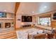 Bright living room features wood floors, a cozy fireplace, a large TV, and natural light from the window at 10137 W Berry Dr, Littleton, CO 80127