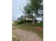 View of home exterior showing yard with mature trees, shed and gravel driveway at 2281 Fairplay St, Aurora, CO 80011
