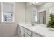 Well-lit bathroom featuring a white vanity, framed mirror, geometric decor, and large window at 5925 Hanover St, Denver, CO 80238