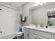 Well-lit bathroom featuring a single sink vanity, framed mirror, and shower with white subway tiles at 5925 Hanover St, Denver, CO 80238