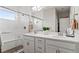 Bright bathroom featuring a double sink vanity, framed mirror, and glass enclosed shower with white subway tiles at 5925 Hanover St, Denver, CO 80238