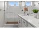 Bright bathroom featuring a sink with framed mirror, and glass enclosed shower with white subway tiles and wood-look flooring at 5925 Hanover St, Denver, CO 80238