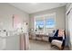 Serene bedroom showcasing a crib, rocking chair, and large window offering picturesque views at 5925 Hanover St, Denver, CO 80238