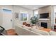 Bright living room with a stone fireplace, large windows, and hardwood floors at 5925 Hanover St, Denver, CO 80238
