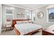 Bright main bedroom features a tray ceiling, light walls, and three windows at 5925 Hanover St, Denver, CO 80238