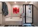 Well-lit bathroom with white tub and separate shower with a decorative accent wall at 676 Hearthstone Ave, Brighton, CO 80601