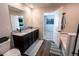 Bathroom featuring double sink vanity with granite countertops, dark cabinetry, and a tub with white tile surround at 676 Hearthstone Ave, Brighton, CO 80601