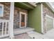 Inviting front entrance with stone accents, a covered porch, and a wood-framed front door at 676 Hearthstone Ave, Brighton, CO 80601