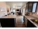 Open kitchen featuring granite countertops and dark cabinetry with easy access to the dining and living areas at 676 Hearthstone Ave, Brighton, CO 80601