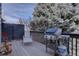 Relaxing back deck with a grill, lounge chair, and beautiful tree view at 14656 W Vassar Dr, Lakewood, CO 80228