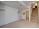 Finished basement area with neutral carpeting and staircase to upper level at 14656 W Vassar Dr, Lakewood, CO 80228