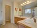 Bathroom with double sinks, tile countertops, and a door leading to a separate toilet at 14656 W Vassar Dr, Lakewood, CO 80228
