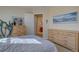 Bedroom with light wood dressers and a view of the ensuite bathroom at 14656 W Vassar Dr, Lakewood, CO 80228