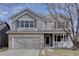 Charming home featuring a covered front porch, two-car garage, and well-maintained landscaping at 14656 W Vassar Dr, Lakewood, CO 80228