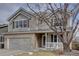 Inviting two-story home with a two-car garage, brick accents, and charming covered porch at 14656 W Vassar Dr, Lakewood, CO 80228