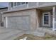 Front exterior showcasing a two-car garage, brick accents, covered porch, and manicured landscaping at 14656 W Vassar Dr, Lakewood, CO 80228