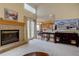 Cozy living room with fireplace, hardwood floors, and open layout to eat-in kitchen at 14656 W Vassar Dr, Lakewood, CO 80228